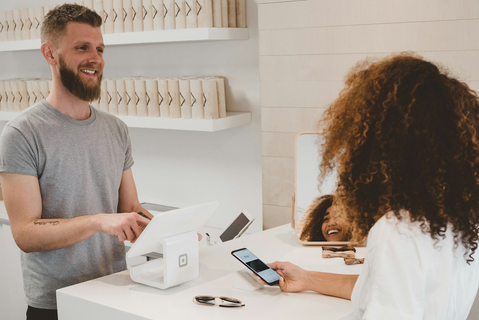 Shop owner taking a contactless payment from a customer at a retail counter