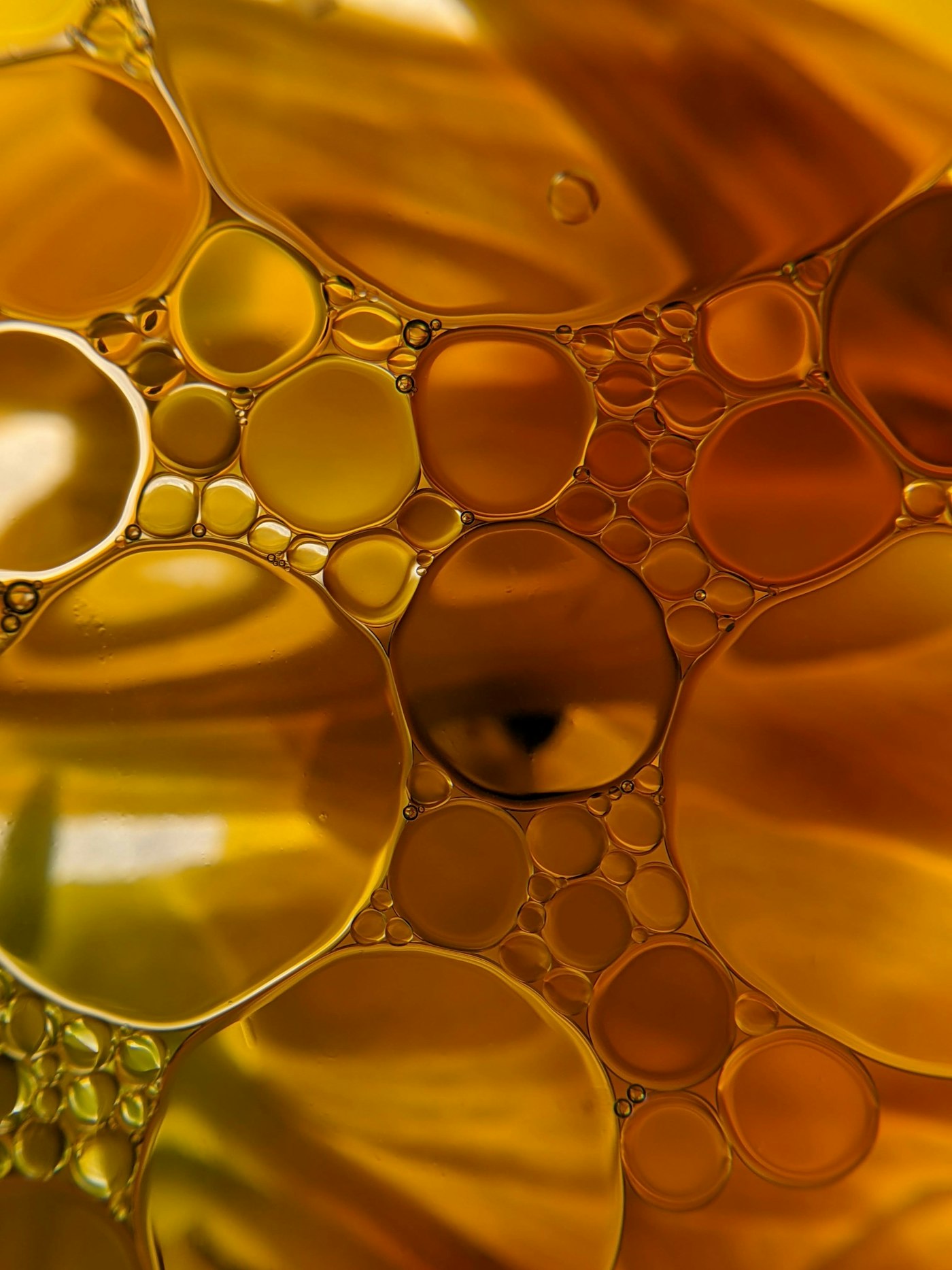 Macro de gotas de aceite dorado formando burbujas